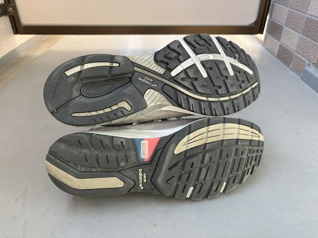 ニューバランス992(下)と993(上)のアウトソールの比較。靴底のデザインとロゴ配置の違い。