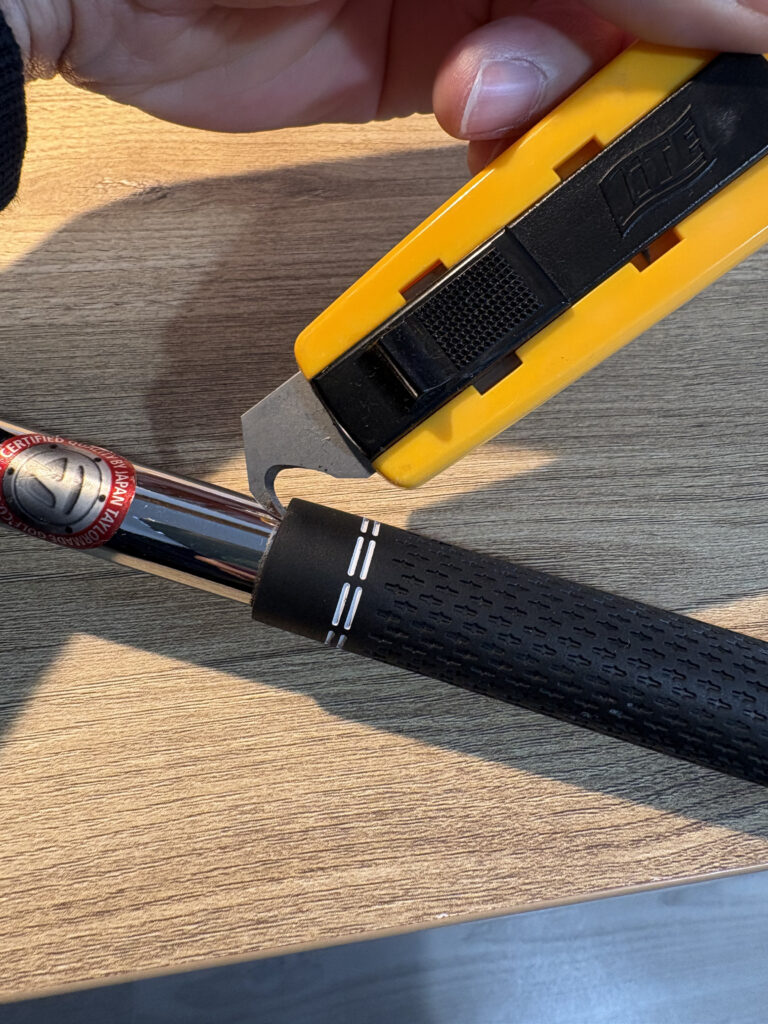 ゴルフグリップ専用カッター（フック刃）で古いグリップを裂く様子