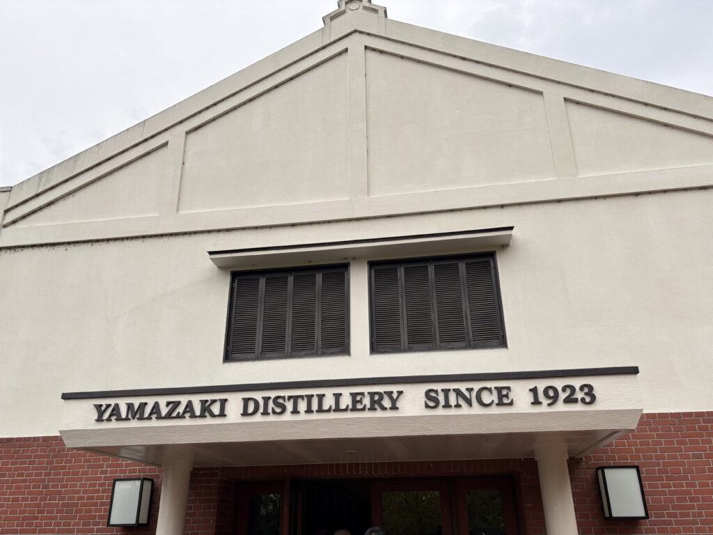 サントリー山崎ウイスキー館の入り口。「YAMAZAKI DISTILLERY SINCE 1923」の文字とレンガ造りの壁。