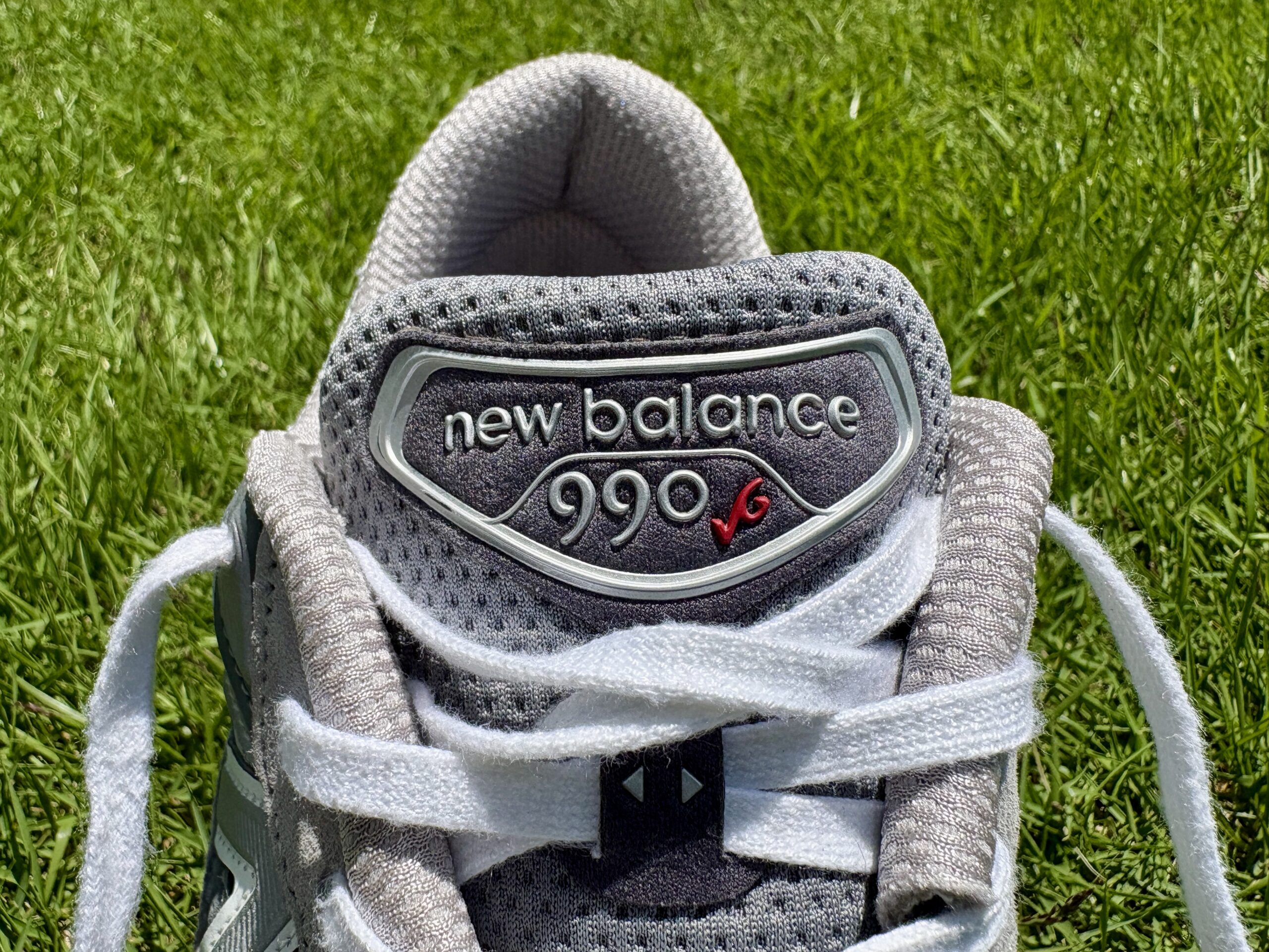 990v6のシュータンアップ。グレーのメッシュ素材に「new balance 990v6」のロゴがデザインされている。